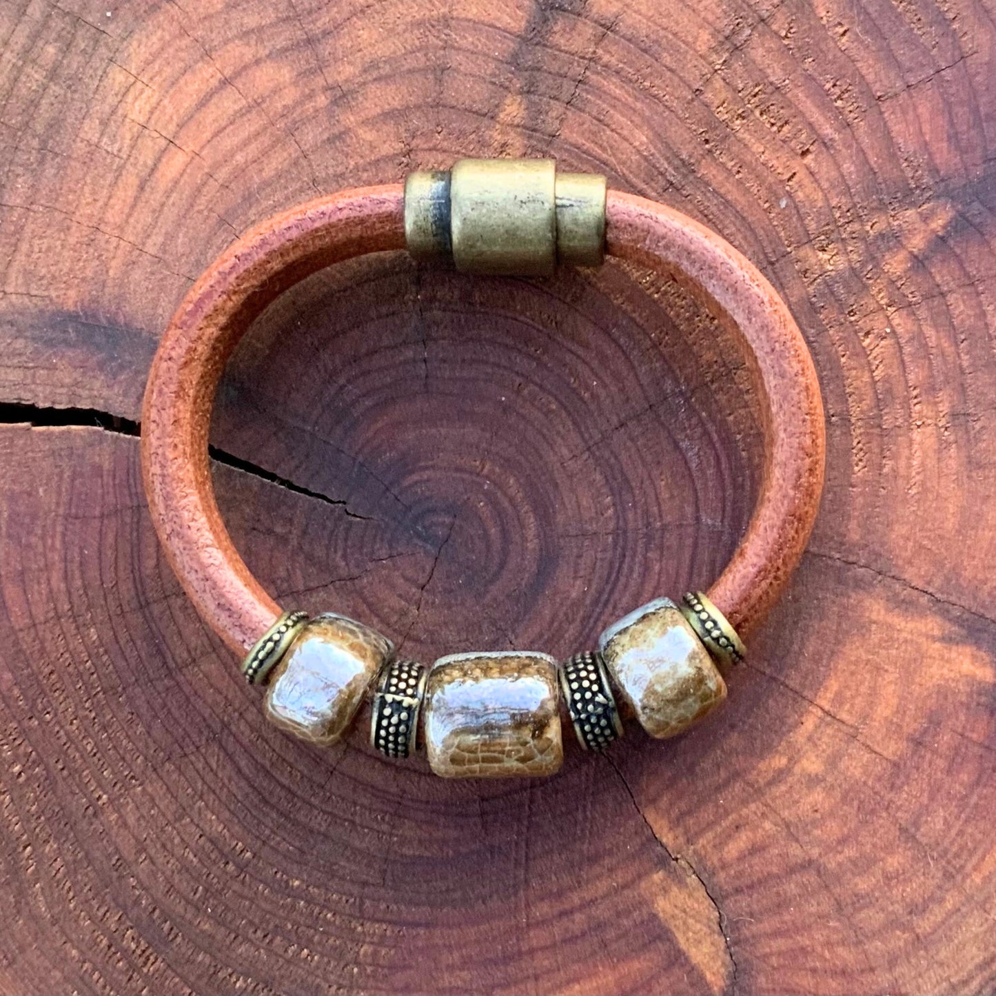 Stylish River Rock Ceramic Bracelet featuring unique glazed beads and antique brass closure, perfect for any occasion.