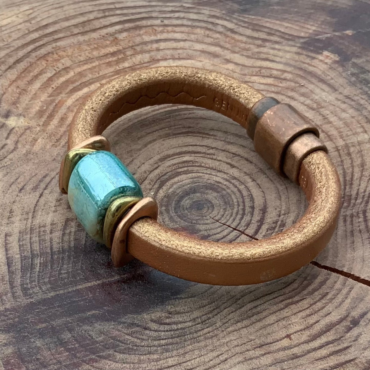 Shimmery copper leather Tuscan Sunset Ceramic Bracelet with a unique blue-green ceramic focal bead and brass accents.