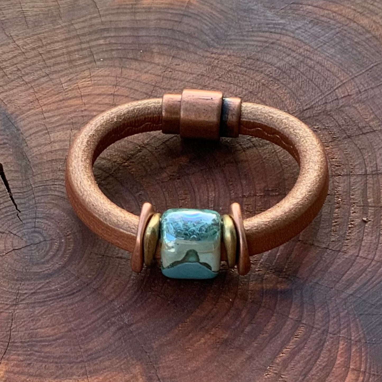 Shimmery copper leather Tuscan Sunset Ceramic Bracelet with unique glazed bead in blues and greens, accented in brass.